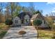 Charming brick home featuring a circular driveway, well-manicured lawn, and mature trees at 103 Devonshire Ln, Salisbury, NC 28146