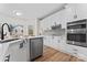 Modern kitchen features stainless steel appliances, white cabinets and backsplash with wood-look floors at 103 Devonshire Ln, Salisbury, NC 28146