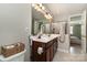 Bright bathroom features a double vanity, framed mirror and neutral toned tiling in the shower at 1030 Archibald Ave, Fort Mill, SC 29708