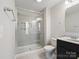 Bathroom featuring tile surround, glass shower enclosure, and black vanity with single sink at 105 Elk Ct, Mount Holly, NC 28120