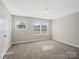 Bright bedroom with two windows, plush carpeting, and neutral paint throughout at 105 Elk Ct, Mount Holly, NC 28120