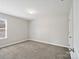 Bedroom featuring plush carpet, neutral paint, a window and a entry door at 105 Elk Ct, Mount Holly, NC 28120