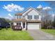 Charming two-story home with a manicured lawn and attached two-car garage at 105 Elk Ct, Mount Holly, NC 28120