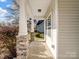 Covered front porch with stone support columns and a view of the neighborhood at 105 Elk Ct, Mount Holly, NC 28120