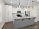 Well-lit kitchen with stainless steel appliances, granite countertops, and a kitchen island with pendant lighting at 105 Elk Ct, Mount Holly, NC 28120
