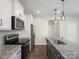 The kitchen has granite countertops, stainless steel appliances, a spacious island, and luxury vinyl plank flooring at 105 Elk Ct, Mount Holly, NC 28120