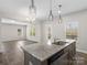 The kitchen has granite countertops, stainless steel appliances, a spacious island, and luxury vinyl plank flooring at 105 Elk Ct, Mount Holly, NC 28120