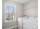 Bright laundry room featuring full size washer and dryer and utility shelving at 105 Elk Ct, Mount Holly, NC 28120
