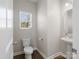 The powder room features a pedestal sink, toilet and a window at 105 Elk Ct, Mount Holly, NC 28120