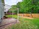 Backyard features a covered patio, a fire pit, and a swing set for outdoor enjoyment at 113 Devynn Ridge Ct, Mount Holly, NC 28120
