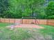 Spacious backyard with a wooden fence and a charming wooden swing set at 113 Devynn Ridge Ct, Mount Holly, NC 28120
