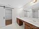 Modern bathroom with dual sink vanity, large mirror, tile flooring, and barn door to closet at 113 Devynn Ridge Ct, Mount Holly, NC 28120