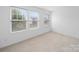 Comfortable bedroom with plush carpeting and natural light from three large windows at 113 Devynn Ridge Ct, Mount Holly, NC 28120
