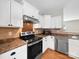 Kitchen featuring stainless steel oven and microwave with tiled backsplash at 113 Devynn Ridge Ct, Mount Holly, NC 28120