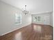 Light room with hardwood flooring, neutral walls, a window, and a modern chandelier at 113 Devynn Ridge Ct, Mount Holly, NC 28120