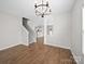 Inviting room with hardwood floors, neutral walls, staircase, and a view of kitchen at 113 Devynn Ridge Ct, Mount Holly, NC 28120