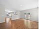Spacious room with hardwood floors, neutral walls, French doors, and view to the kitchen at 113 Devynn Ridge Ct, Mount Holly, NC 28120