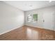 Bright room with wood-look flooring, white walls, a window, and an entrance door at 113 Devynn Ridge Ct, Mount Holly, NC 28120