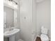 Half bathroom with pedestal sink, wall mirror, and a tiled floor at 113 Devynn Ridge Ct, Mount Holly, NC 28120