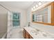 A well-lit bathroom featuring a vanity with storage, a large mirror, and a shower-tub combo at 11333 Snapfinger Dr, Charlotte, NC 28277