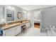 Bright bathroom with double vanity, tile floor, and an entrance to the bedroom at 11333 Snapfinger Dr, Charlotte, NC 28277