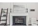 Elegant fireplace with white mantel, decorative art, and display shelves, creating a warm focal point at 11333 Snapfinger Dr, Charlotte, NC 28277