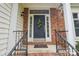 Welcoming front entrance with brick accents, black railing, and decorative wreath on the door at 11333 Snapfinger Dr, Charlotte, NC 28277