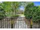 Fenced backyard featuring green lawn, manicured shrubbery, and stone walkway at 128 Front Porch Dr, Rock Hill, SC 29732