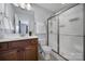 Bathroom features a wood vanity, shower with glass doors, white towels, and tile floors at 128 Front Porch Dr, Rock Hill, SC 29732