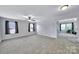 Spacious bedroom featuring neutral carpet, ceiling fan, and plenty of natural light from two windows at 128 Front Porch Dr, Rock Hill, SC 29732