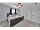 Cozy bedroom with neutral gray walls, gray carpet, black bed frame, and a ceiling fan at 128 Front Porch Dr, Rock Hill, SC 29732