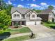 Beautiful two-story home with a three car garage and landscaped front yard on a sunny day at 128 Front Porch Dr, Rock Hill, SC 29732