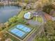 Aerial view featuring tennis courts and a pool amidst a lush lakeside neighborhood at 130 Villa Lake Dr, Fort Mill, SC 29708