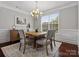 Charming dining area with a rustic wooden table, stylish chairs, and a decorative chandelier fixture at 130 Villa Lake Dr, Fort Mill, SC 29708