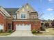Charming brick townhome featuring a two-car garage, well-kept lawn, and inviting curb appeal at 130 Villa Lake Dr, Fort Mill, SC 29708