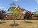 Elegant brick home showcasing a lush front yard, mature trees, and classic architectural details at 130 Villa Lake Dr, Fort Mill, SC 29708