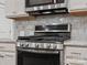 Close-up of stainless steel oven and gas range nestled among white cabinets and granite countertops at 130 Villa Lake Dr, Fort Mill, SC 29708