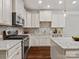 Modern kitchen with stainless steel appliances, white cabinets, granite countertops, and hardwood floors at 130 Villa Lake Dr, Fort Mill, SC 29708