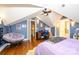 Bedroom in finished attic with hardwood floors, ceiling fan, desk, and sitting area at 139 S Laurel Ave, Charlotte, NC 28207