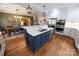Open-concept kitchen offers a blue island, white cabinetry, stainless appliances, and seamless flow to the dining area at 139 S Laurel Ave, Charlotte, NC 28207