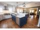 Well-appointed kitchen with stainless steel appliances, blue island, quartz counters, and hardwood floors flowing into dining area at 139 S Laurel Ave, Charlotte, NC 28207