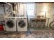 Laundry room equipped with modern washer and dryer units, table, and stool seating at 139 S Laurel Ave, Charlotte, NC 28207