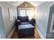 Small sitting room with comfortable chair and ottoman next to window at 139 S Laurel Ave, Charlotte, NC 28207