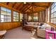Relaxing sun room boasts wood-paneled walls, large windows, a comfortable seating area, and ample natural light at 139 S Laurel Ave, Charlotte, NC 28207