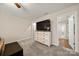Carpeted bedroom showcasing a large dresser with a TV and an open doorway to a bathroom at 1430 Whitman Ct, York, SC 29745