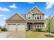 Charming two-story home featuring a welcoming front porch and a spacious three-car garage at 1430 Whitman Ct, York, SC 29745