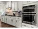 Modern stainless-steel double ovens integrated into the kitchen's white cabinetry and granite countertops at 1430 Whitman Ct, York, SC 29745