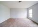A minimalist bedroom with light blue walls, a large window, and neutral carpeting at 1459 Wehunt Store Rd, Cherryville, NC 28021