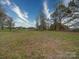 Large grassy land lot for sale with scattered trees and a home in the background at 1459 Wehunt Store Rd, Cherryville, NC 28021