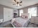 Bedroom with gray walls, a ceiling fan, and a comfortable bed with purple floral bedding at 15211 Windward Ln, Lancaster, SC 29720